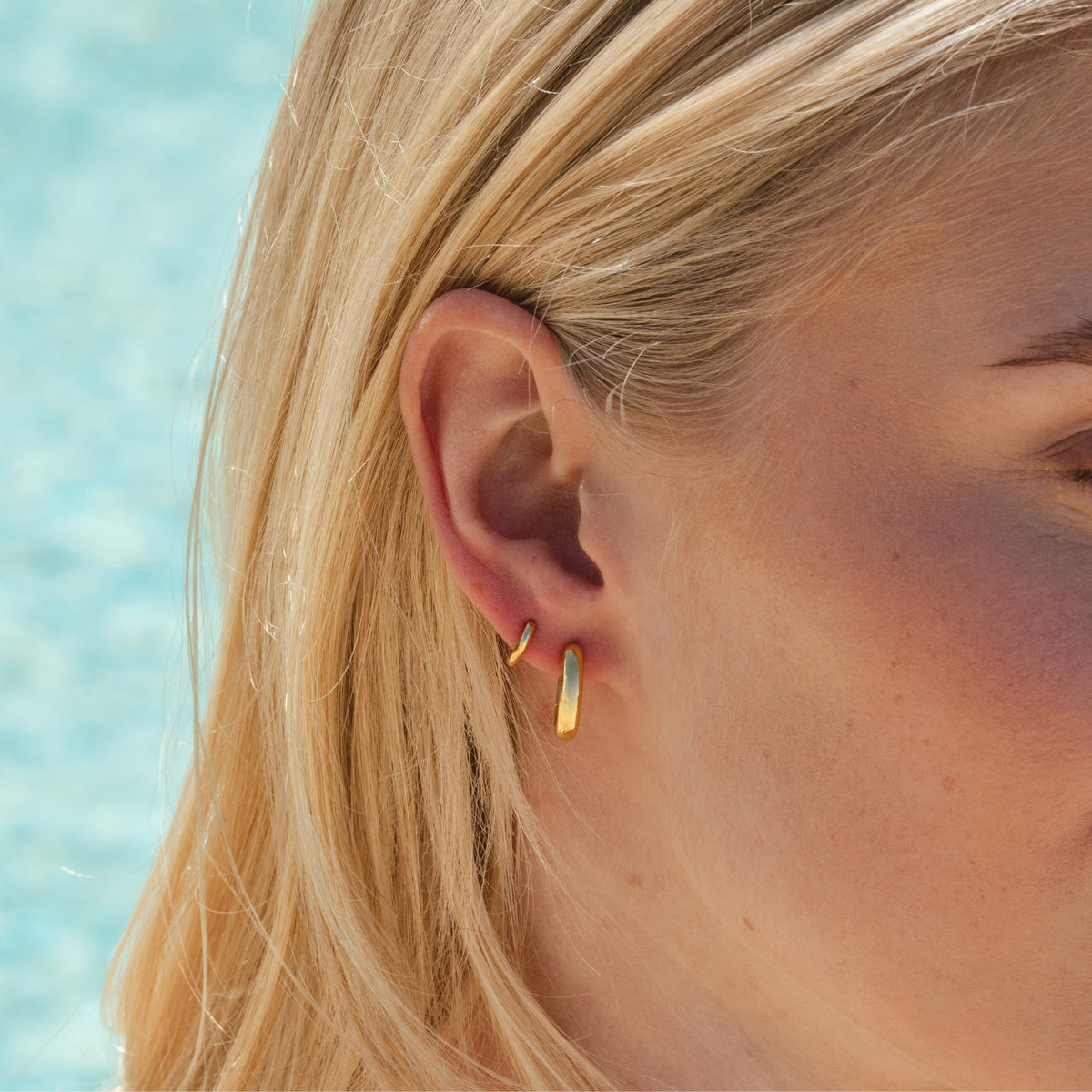 Gold Oval Huggies on model showing fit on ear