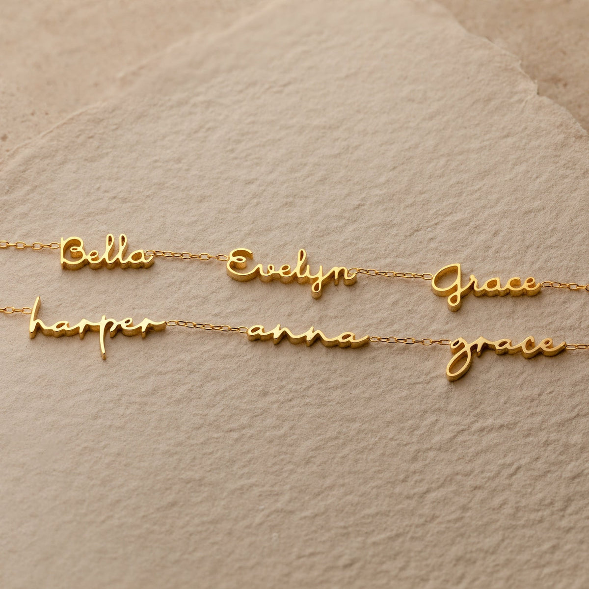 Three gold Dainty Tiny Multiple Name Necklaces display the names Bella, Evelyn, Grace, Harper, Anna, and Grace on beige paper—a perfect personalized accessory for lovers of dainty necklace styles.