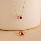 Toi et Moi Birthstone Necklace featuring pink square and red teardrop gemstones on a beige background—ideal for anyone seeking personalized gemstone or custom birthstone jewelry.